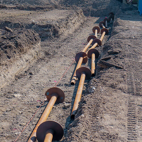 Helical piers laid out in preparation for installation
